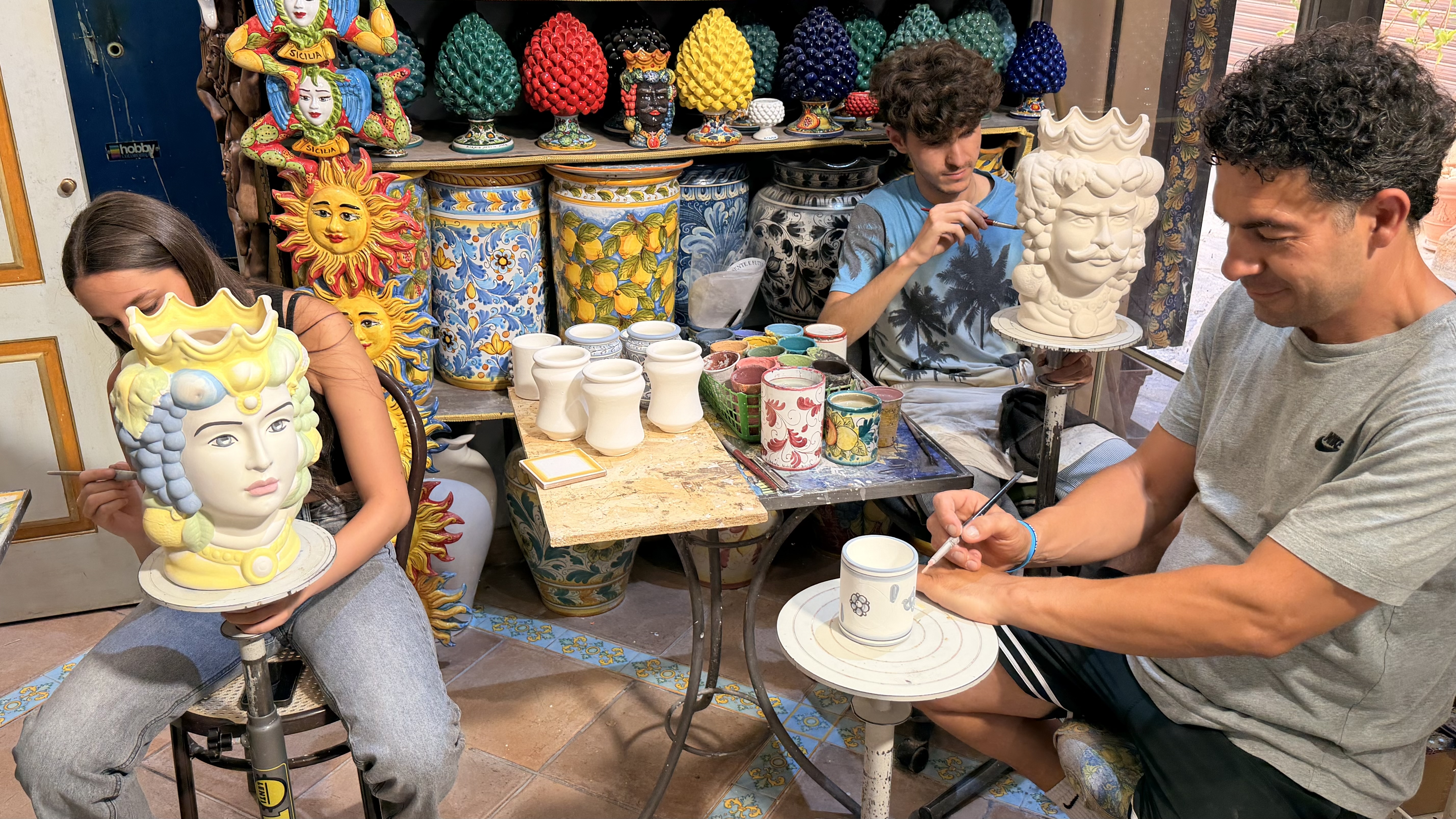 La famiglia Cascio dipinge le ceramiche nella bottega di Sciacca